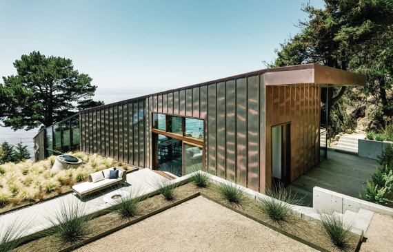 Outdoor living spaces and a green roof lie along the house’s south wall, sheltered from northwest winds.