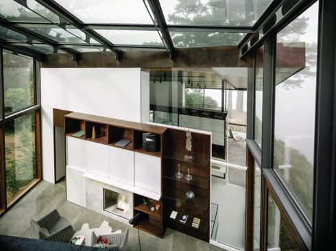 The kitchen overlooks the library/den, which forms a transparent link to the master bedroom volume.