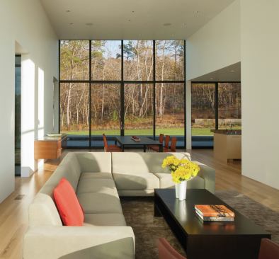Glass end walls at the first-floor common spaces channel views in two directions. This perspective is from the living area through the dining area and out to the pool deck.
