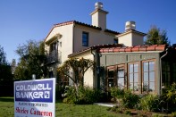 A realty sign stands in front of a home in the Crystal Cove section of Newport Beach, California, U.S., on Monday, Dec. 14, 2009. Homeowners with mortgages of more than $1 million are defaulting at almost twice the U.S. rate and turning to so�called short sales to unload properties as stock�market losses and pay cuts squeeze wealthy borrowers. This 3,664 square foot home is owned by BORM Inc. Co�founder Masoud Bakaie, who owes $2.6 million on the property and is seeking approval of a short sale. Photographer: Tim Rue/Bloomberg