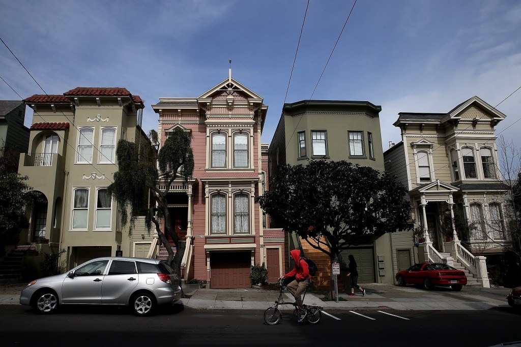 SAN FRANCISCO, CA - FEBRUARY 18:  A bicyclist rides by a row of homes on February 18, 2014 in San Francisco, California. According to a report by mortgage resource site HSH.com, an annual salary of $115,510 is needed to purchase a house in San Francisco where the median    home price is $682,410. The report included 25 of the nations largest metropolitan cities with Cleveland, Ohio being the cheapest with a needed salary of $19,435 to purchase a home.  (Photo by Justin Sullivan/Getty Images) ** OUTS - ELSENT, FPG, TCN - OUTS * NM, PH, VA if sourced by CT, LA or MoD **