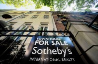 A Sotheby's "For Sale" sign is displayed outside of a townhouse in New York, U.S., on Monday, June 23, 2014. Americans snapped up previously owned homes in May in the biggest monthly sales gain in almost three years, a sign the residential real estate market is regaining its footing after a stumble early in the year. Photographer: Craig Warga/Bloomberg ** Usable by CT and LA Only **