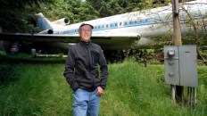 Bruce Campbell stands near his Boeing 727 home in the woods outside the suburbs of Portland, Oregon May 21, 2014. In 1999, the former electrical engineer had a vision: To save retired jetliners from becoming scrap metal by reusing them. Campbell, 64, is one of a small number of people worldwide who have transformed retired aircraft into a living space or other creative project, although a spokesman for the Aircraft Fleet Recycling Association was unable to say precisely how many planes are re-used this way. Picture taken May 21.  REUTERS/Steve Dipaola  (UNITED STATES - Tags: SOCIETY TRANSPORT REAL ESTATE) - RTR3SP8I