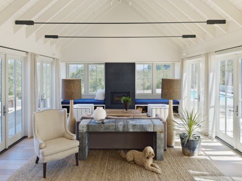 The glass-enclosed living room looks out on the courtyard a pool.
