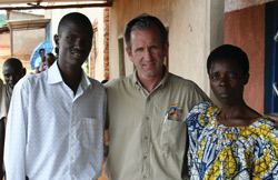 Jeff Rutt visits with HOPE Rwanda staffer Charles Rwomushana (left) and a loan recipient.