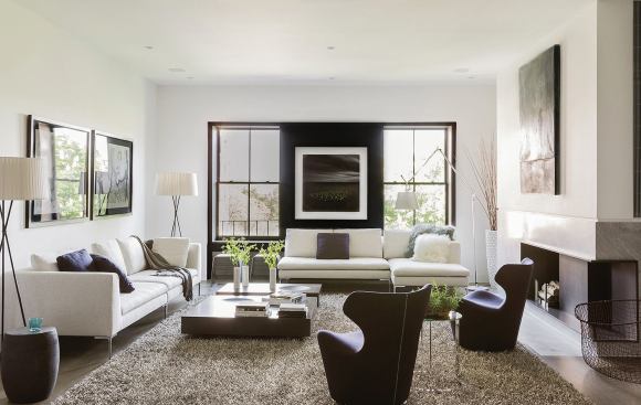 A recess that combines two double-hung windows into one visual element and an asymmetrical fireplace mantel modernize the living room.