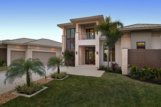 The three-car garage recedes to the side on the wedge-shaped lot.