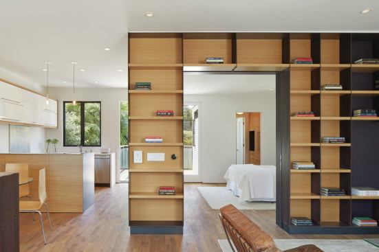Steel was used for exterior siding as well as interior detailing like these built in bookshelves that enclose a bedroom. 