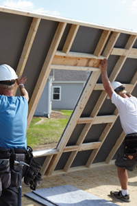 Men holding up a wall.