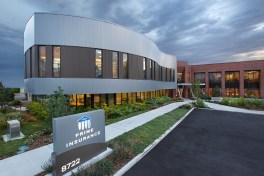 Exterior featuring new addition, stretching outwards in a fluid curve.