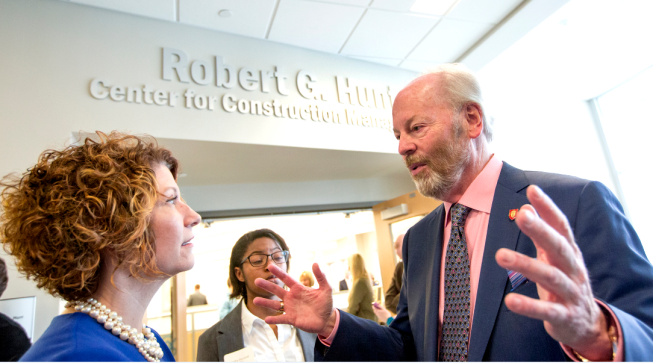 Robert G. Hunt (right) speaks with Jennifer Bott, dean of the Miller College of Business, outside of the new center at Ball State.