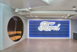 Ford’s office pays homage to Ford Motor Company and Lincoln Motor Company’s iconic branding with the entrance’s 3-D, Ford-blue feature wall. The custom edge LED lit millwork wall by K. Mack Enterprises showcases a floating aluminum, satin-finish Ford logo anchored in an interlocked Lincoln-logo mesh grid. The polished aluminum behind the white lacquered logo draws attention to the wall.