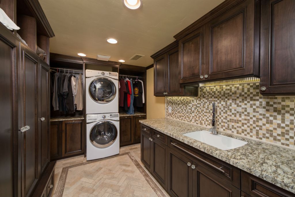 Hochuli Design & Remodeling Team used popular materials like stone flooring, custom cabinetry, and glass mosaic tile for this revitalized space.