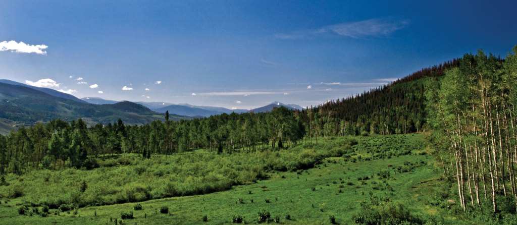 Summit Sky Ranch will be located in a valley, surrounded by aspen trees.
