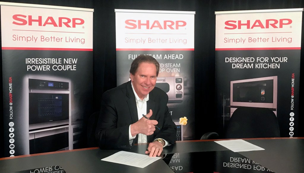 Peter Weedfald, senior vice president of sales & marketing at Sharp Electronics Marketing Company of America, signs the contract between Sharp and Nationwide.