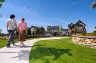 Young couple walking to their new suburban house holding hand in hand in bright summer afternoon day