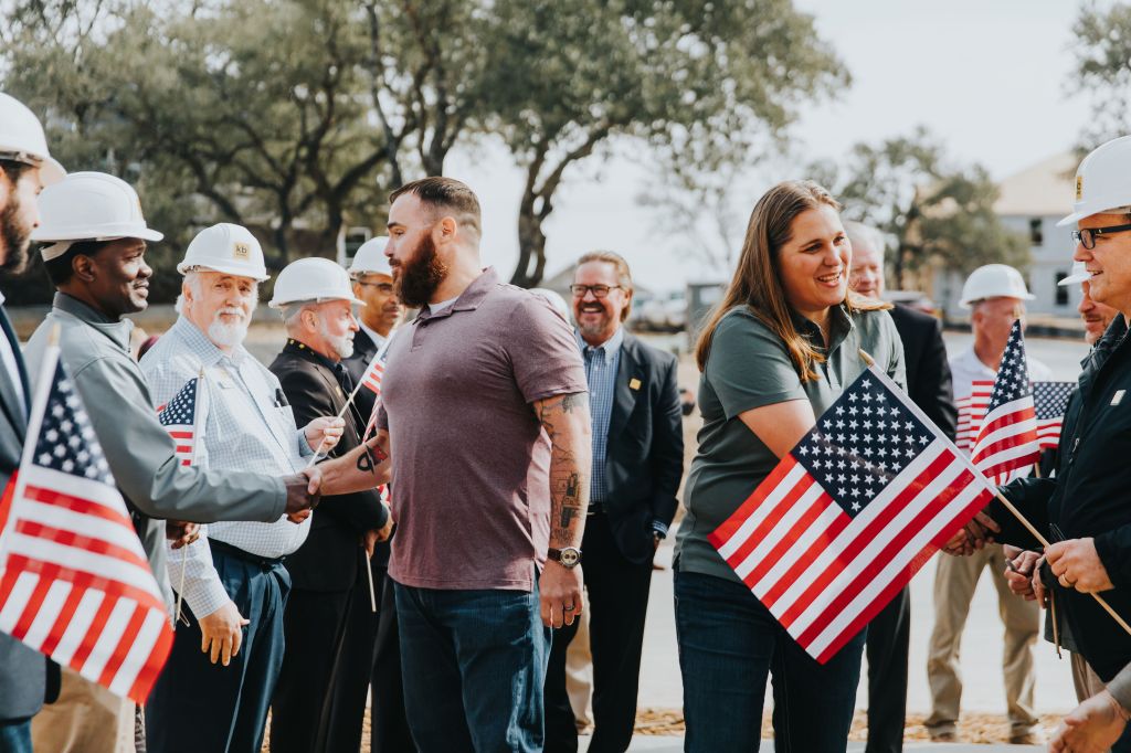 Walking into their forever home, Reese and Kyle Hines are thanked by KB Home military veteran employees for their service. This mortgage-free home was built and gifted to the Hines family in partnership with KB Home and Jared Allens’s Homes for Wounded Warriors.