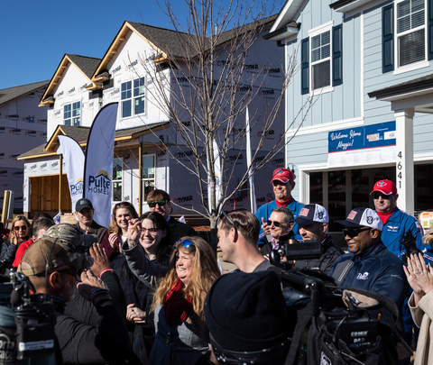Gold Star spouse Maggie Duskin holds up the key to her new mortgage-free home in Pulte's Rutherford community.