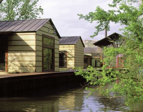 A simple boardwalk connects a sequence of small buildings with the screened-in boathouse. "We're excited about the notion of a village along a canal," says principal in charge Ted Flato.