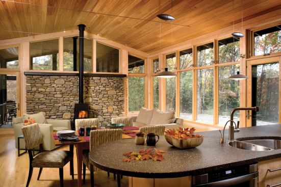 The living room is bright and airy, combining natural materials with high-performance windows to create a bright and comfortable space.