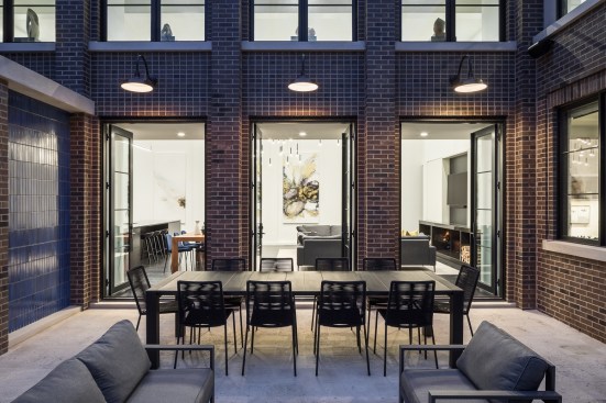 A trio of doors from the double-height great room open onto the enclosed courtyard space.