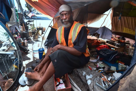 Homeless veteran Kendrick Bailey keeps cool inside his tent on a street corner near Skid Row in downtown Los Angeles.