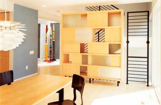 A display case of maple, glass, and aluminum, designed by McInturff Architects, defines the dining room without blocking the light traveling in through the east and west facades.