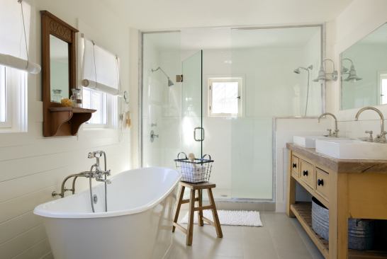 The master bath seamlessly blends traditional elements—such as the antique pine work table top with reclaimed base and Rohl Country Bath faucets—with a decidedly modern, all-glass shower and a Toto Aquia dual-flush toilet.