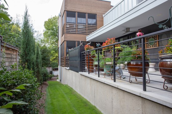Patio along one side of the house. The stacked screen  porches can be seen beyond it.