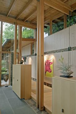 The outside walkway extends into the house as a corridor connecting the two wings.