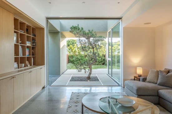 Two-Story Atrium: Beyond the kitchen and the family room, the atrium space with a 30-year-old Japanese black pine brings natural light to the rear of the home and the master suite.