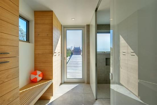 This entryway is able to pull double-duty as a compact bath thanks to well-located built-in cabinetry that provides linen storage and conceals other bathroom essentials. Project: Ocean Bay Cabana Bath, Water Mill, N.Y.; Builder: Witty & Gazda, Sagaponack, N.Y.; Architect: Stelle Architects, Bridgehampton, N.Y.