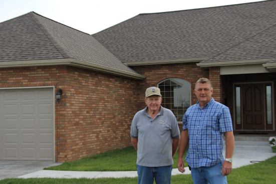 Everett Wallace and Gary Rose in front of the Wallaces' new house, built by HBA board member Gary Rose on the site of their old home. The previous house was totaled in the storm, along with the Wallaces' cars and possessions."