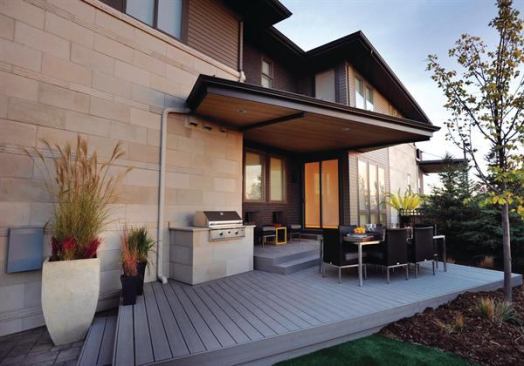 This alley-loaded lot squeezes in an outdoor space on the side of the home complete with the outdoor kitchen essentials. There's a built-in grill on the side façade and a roof and porch that echo the home's unusual angles. The porch was built with wood from trees killed in Colorado's pine beetle plague. 
Project: Lime Model at Stapleton, Denver; Architect: Woodley Architectural Group, Littleton, Colo.; Builder: Infinity Home Collection, Denver