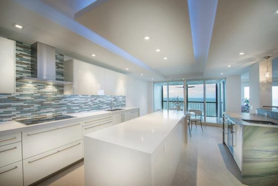 The rectilinear island and ceiling soffit draw attention toward stunning ocean view.