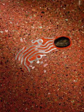 Cheng often embeds bits of ephemera in his concrete countertops; they’re like present-day fossils. Here, a tiny geode seems to float across the counter like a sea creature or a bit of jetsam. The wake appears to be made of inlay, but that’s actually a piece of valve body cover from an automatic car transmission, a bit of modern-day jetsam.