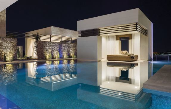 Elegantly mirrored in the zero-edge pool, a stand-alone covered patio offers a relaxing respite for yoga, an artist’s studio, or an afternoon nap.