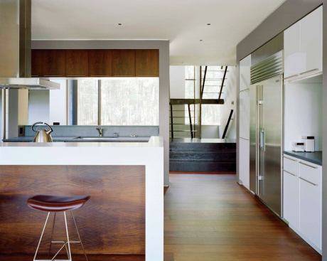 The kitchen, which fills a space that was once an interior courtyard, mixes black walnut panels and Corian counters with off-the-shelf cabinets.