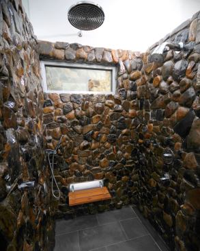 A master bath’s shower clad in large river rocks offers a nature-inspired refuge. Project: Heyne Residence, Dallas; Architect/Builder: RPGA Design Group, Fort Worth, Texas