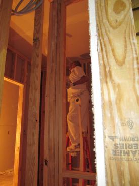 A worker at the Rocky Mount plant applies drywall tape to interior walls and ceiling. IBS’s factories have the capacity to virtually complete a module’s interiors if the builder requests that service.