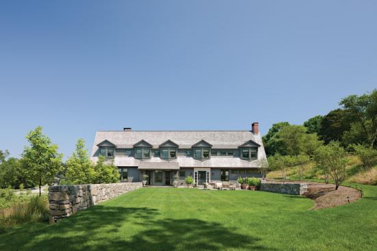 The south elevation's simple roof form anchors a relaxed composition of dormers and bay windows serving the bedrooms.