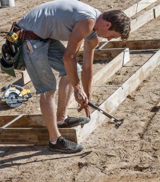 Figure 2. Footing forms are fastened together at the corners with duplex nails; 16-inch metal spreaders keep the sides properly spaced.