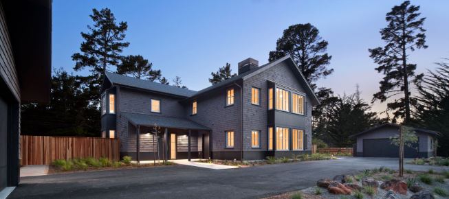 Twin garages connected by a shared access road stand on either side of the duplex. What normally would be the back of the house is actually the front elevation just off the main road leading to the main campus.