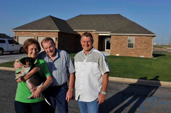 Tornado survivors Eileen and Everett Wallace with dog Gus with homebuilder and Joplin HBA board member Gary Rose in front of the Wallace’s new home in Joplin. “I told Everett, ‘Gary Rose is the only builder I know.’” says Eileen Wallace. “‘I trust Gary, I know he builds a good house, and I know he’s not going to leave town.’” Says Gary Rose: “I’m in this for the long haul.”