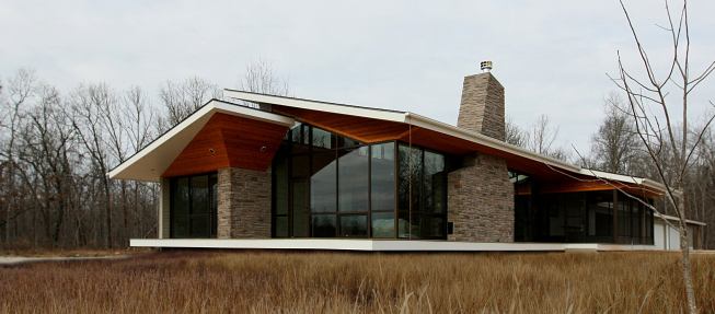 Stone gives a rugged contrast to the stained cedar soffits incorporated into this home’s geometric design. The stone chimney also offers an earthbound dimension to a house that, thanks to its floating roof, almost seems as if about to take flight. Project: AB Highway Residence, West Plains, Mo.; Architect: Core 10 Architecture, St. Louis; Builder: Feller Construction, West Plains