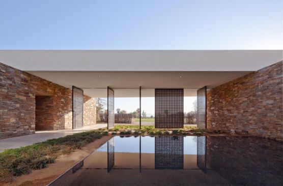 Laser-cut aluminum screens pivot to open the entry courtyard.