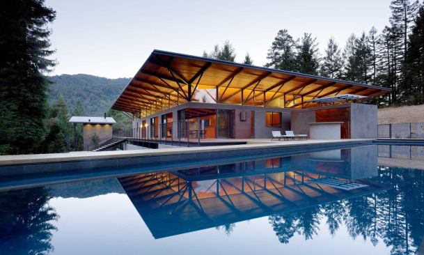 The canopied structure between the house and the pool holds a sauna, changing area, half bath, and outdoor kitchen.