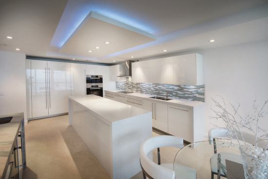 The island separates work zones, so the compact kitchen can accommodate a single home cook or a group of caterers.