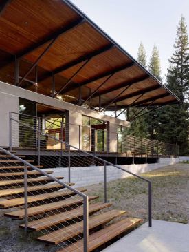 The steel-framed deck floats above a concrete retaining wall, just as the roof floats above the house’s stucco exterior wall.