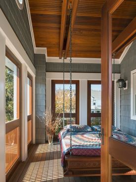 Everybody's favorite space in this house is the sleeping porch. The porch flooring and ceiling are mahogany; the bed hangs from in between paired beams. There's a solid block in between the beams and a vertical bolt through the block.